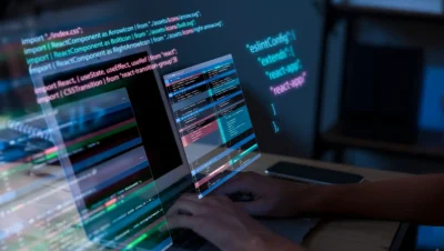 Profissional de TI trabalhando com código de programação e segurança digital, representando estratégias de cibersegurança em 2025 para ambientes descentralizados.