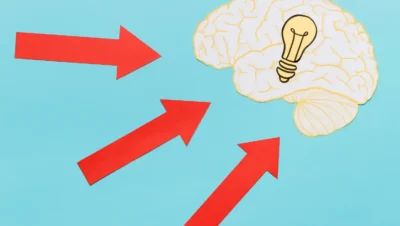 Imagem ilustrativa demonstrando o efeito ancoragem e a aversão à perda na estratégia de preço, com setas indicando influência no pensamento, representado por um cérebro com uma lâmpada.