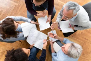 Grupo de pessoas discutindo estratégias de marketing usando prova social e autoridade em uma reunião moderna e colaborativa.