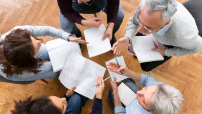 Grupo de pessoas discutindo estratégias de marketing usando prova social e autoridade em uma reunião moderna e colaborativa.
