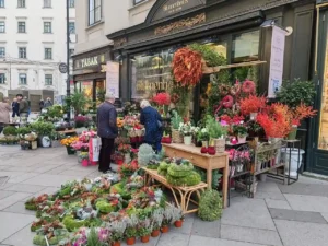 Vários clientes fazendo compras em uma loja de flores na rua, com filas e vitrines atraentes que demonstram a importância da prova social no varejo.
